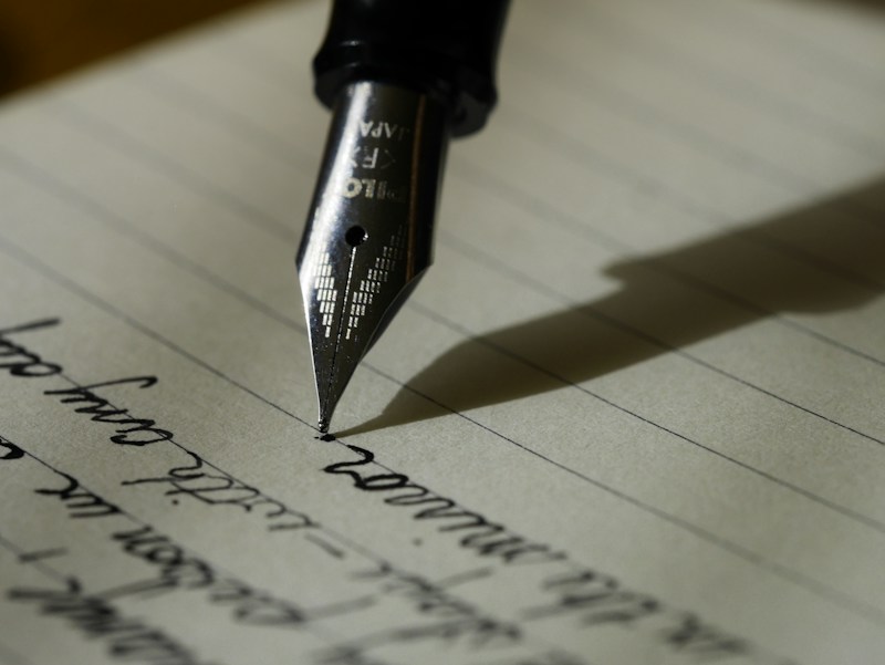 Writing in a notebook to develop brand narratives and messaging